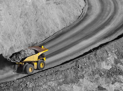 Mining operation underway as truck carries rocks from quarry for processing